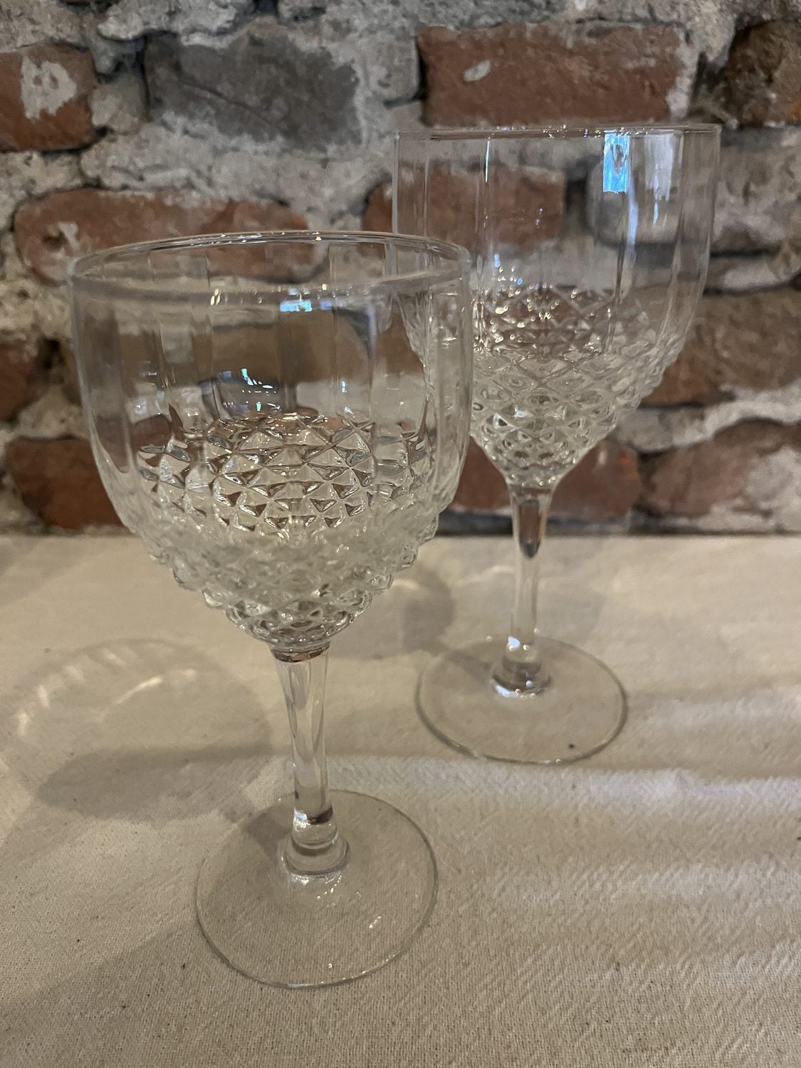 Twee wijnglazen op voet met een geslepen diamantmotief, een groot en een kleiner